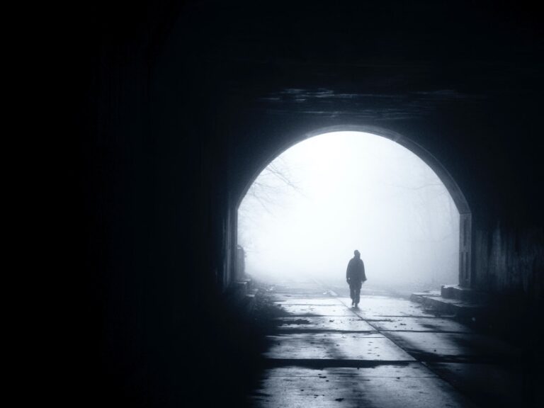 person walking alone into the light
