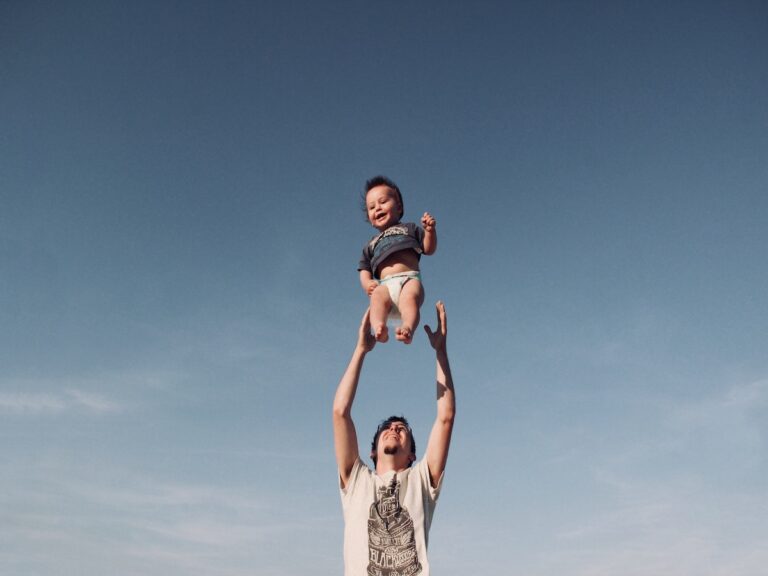 father tossing baby into the air