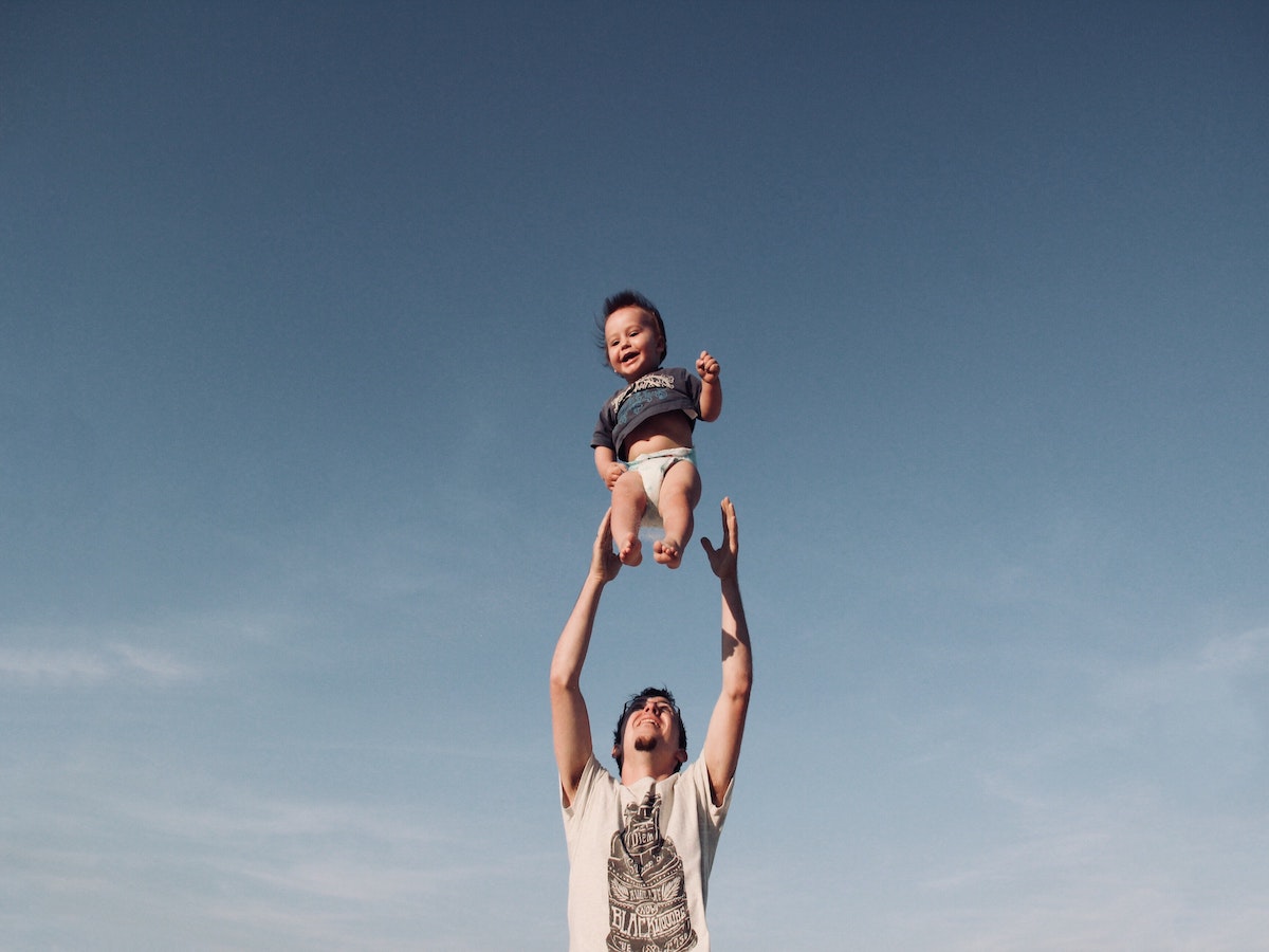 father tossing baby into the air